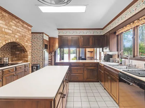 a kitchen with stainless steel appliances a sink window and cabinets