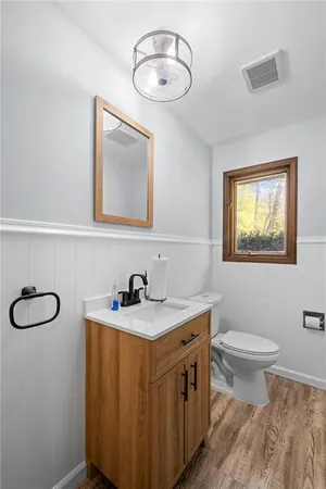 a bathroom with a sink a toilet and mirror