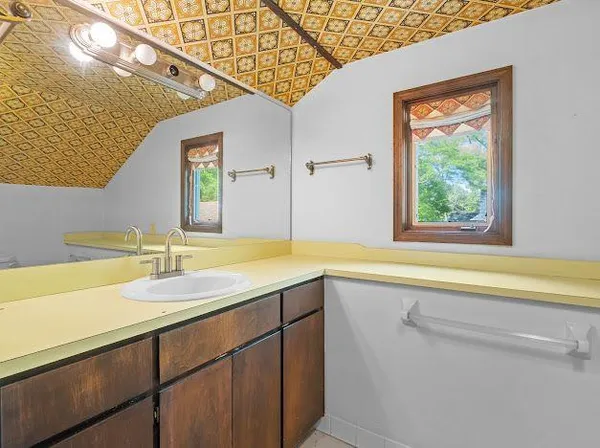 a bathroom with a granite countertop sink and a large mirror