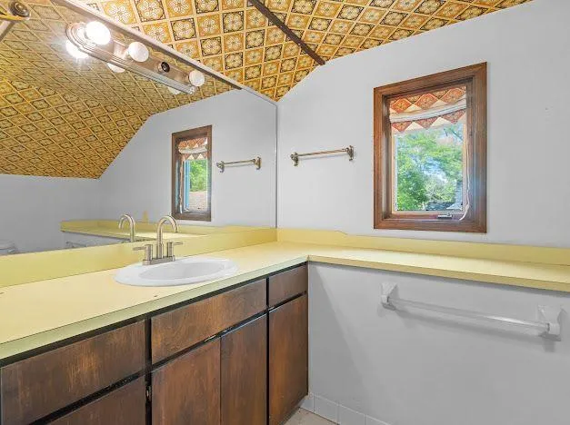 a bathroom with a granite countertop sink and a large mirror