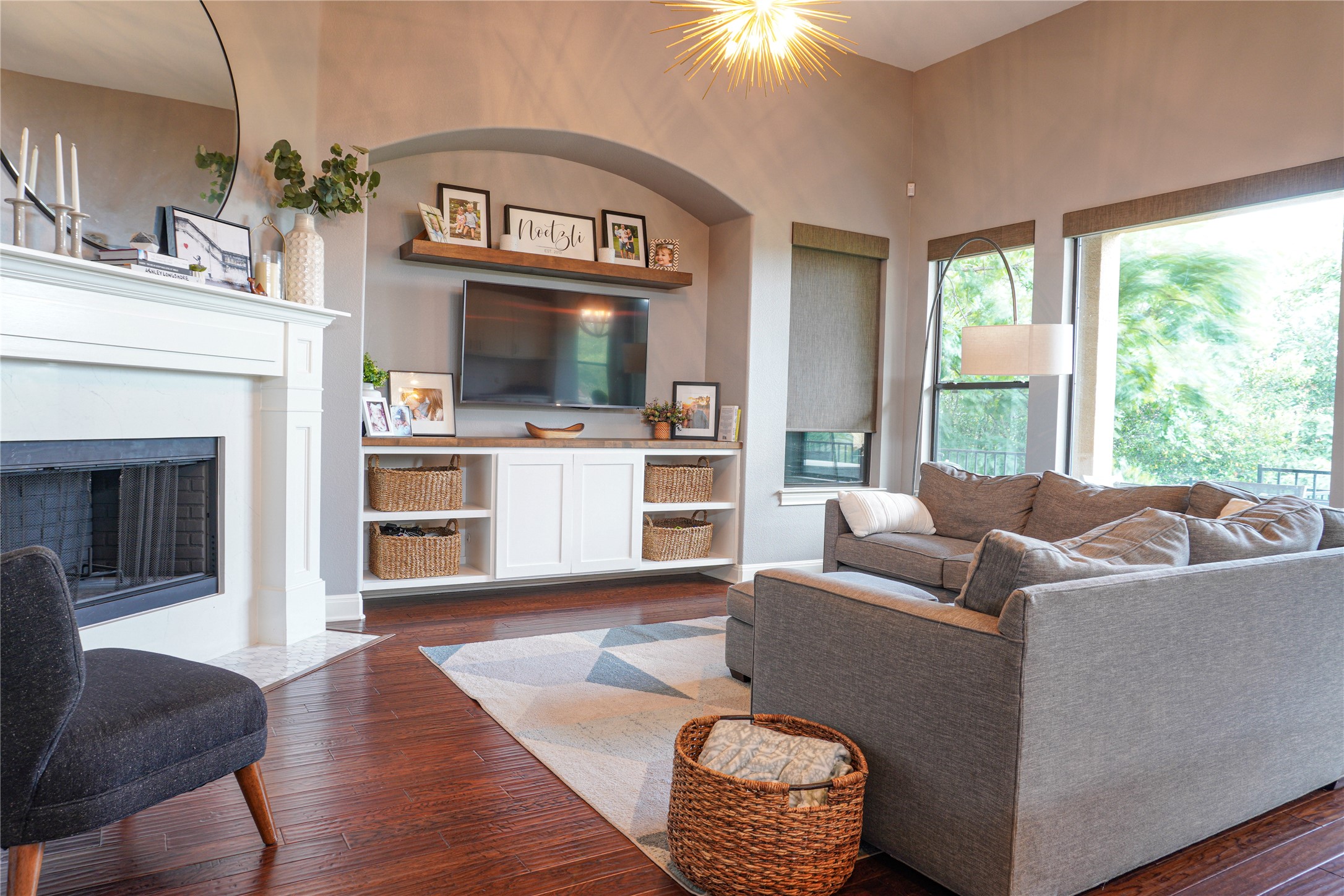 102 Indigo Run Cove Austin, TX 78738 - Photo 5 of 24 Living room with dark wood-style flooring, a fireplace, and hanging lights