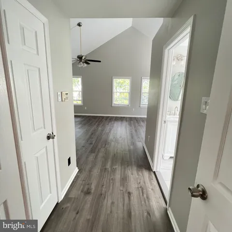 a view of a hallway with wooden floor and staircase