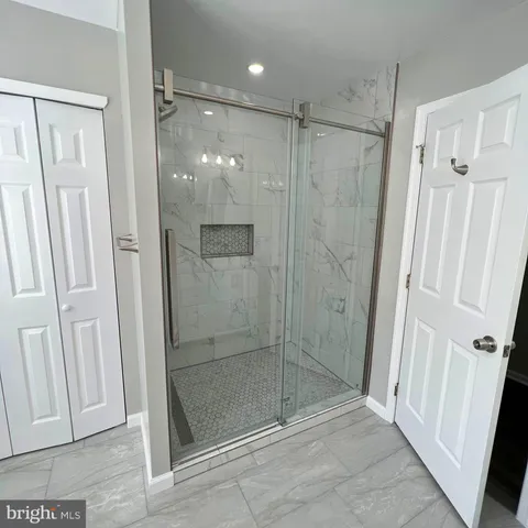 a bathroom with a shower and a glass door