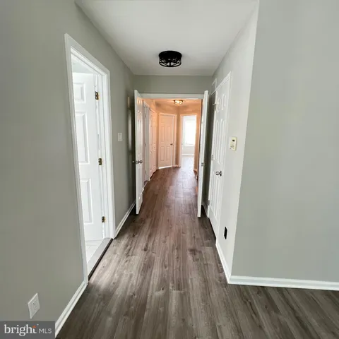a view of a hallway with wooden floor and closet