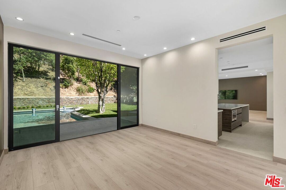 9719 Blantyre Drive Beverly Hills, CA 90210 - Photo 11 of 43 an empty room with wooden floor and windows