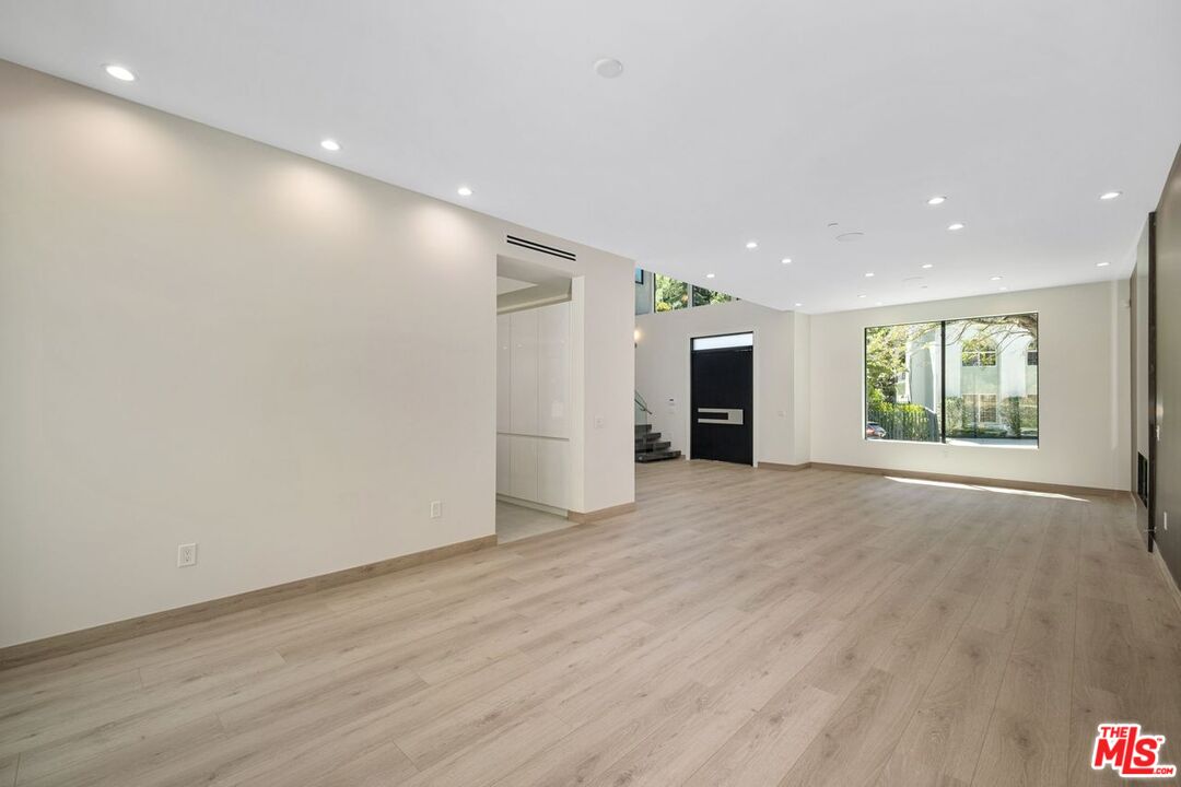 9719 Blantyre Drive Beverly Hills, CA 90210 - Photo 12 of 43 an empty room with wooden floor and windows