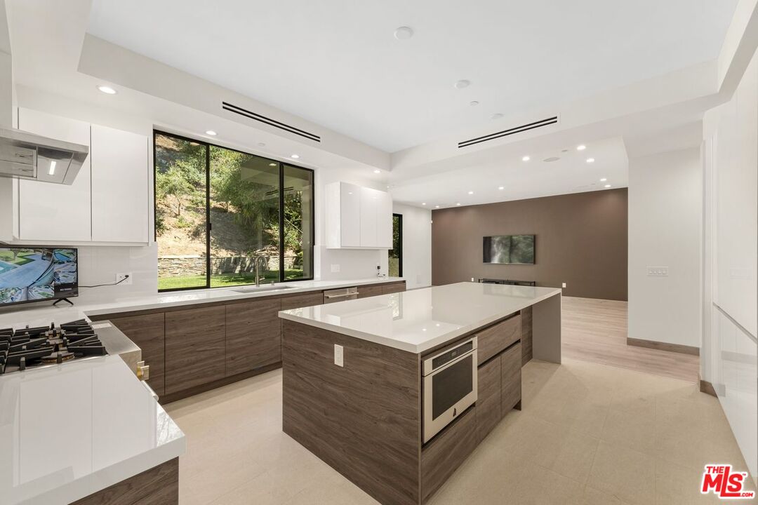 9719 Blantyre Drive Beverly Hills, CA 90210 - Photo 14 of 43 a kitchen with a stove a sink and a refrigerator