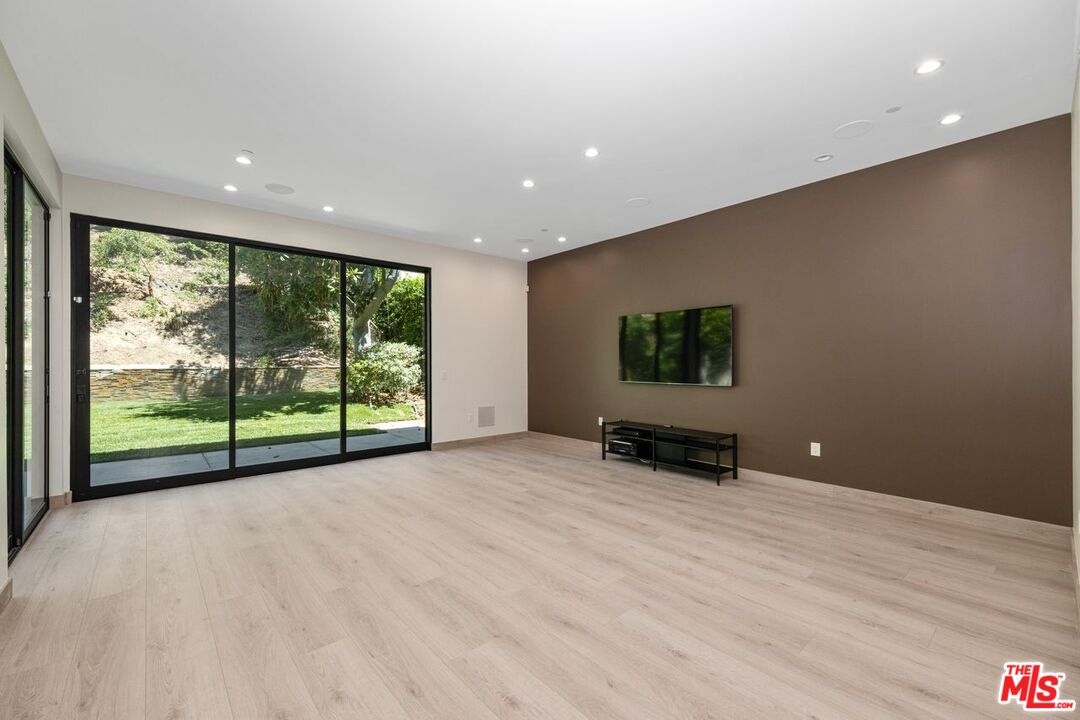 9719 Blantyre Drive Beverly Hills, CA 90210 - Photo 19 of 43 a view of an empty room with wooden floor and a window