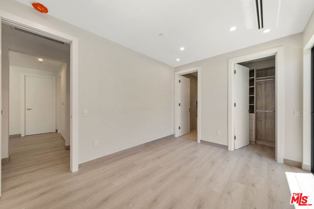 9719 Blantyre Drive Beverly Hills, CA 90210 - Photo 27 of 43 an empty room with wooden floor and windows