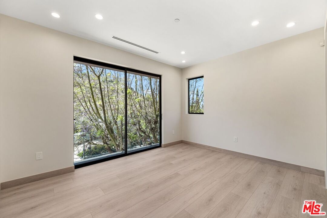 9719 Blantyre Drive Beverly Hills, CA 90210 - Photo 28 of 43 a view of an empty room with wooden floor and a window