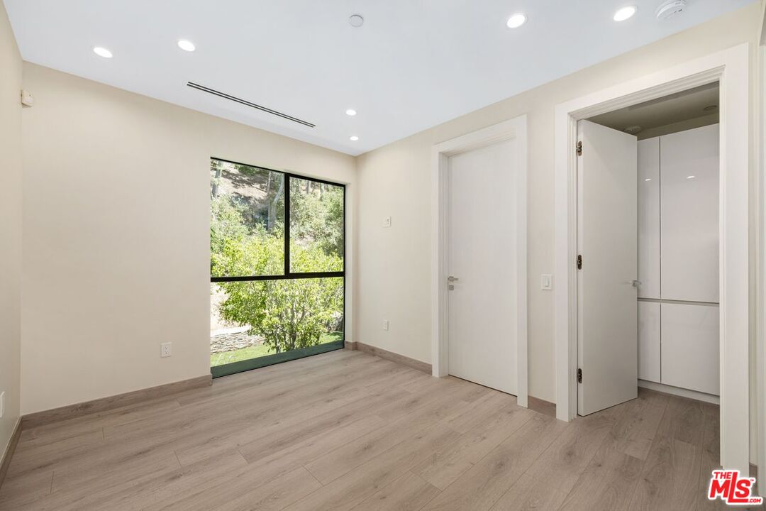 9719 Blantyre Drive Beverly Hills, CA 90210 - Photo 30 of 43 a view of an empty room with wooden floor and a window