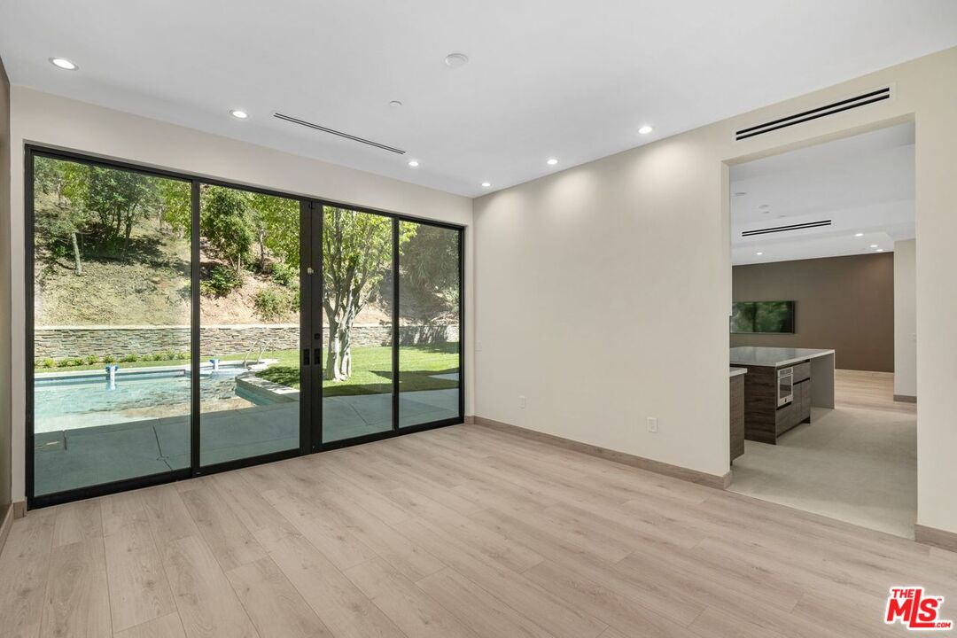 9719 Blantyre Drive Beverly Hills, CA 90210 - Photo 10 of 43 a view of an empty room with wooden floor and a balcony