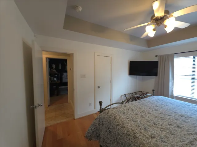 a bedroom with a bed and a flat tv screen on dresser