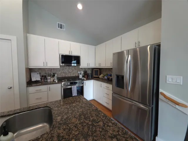 a kitchen with a refrigerator stove and microwave