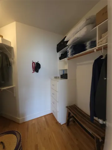 a view of walk in closet with clothes and shoes