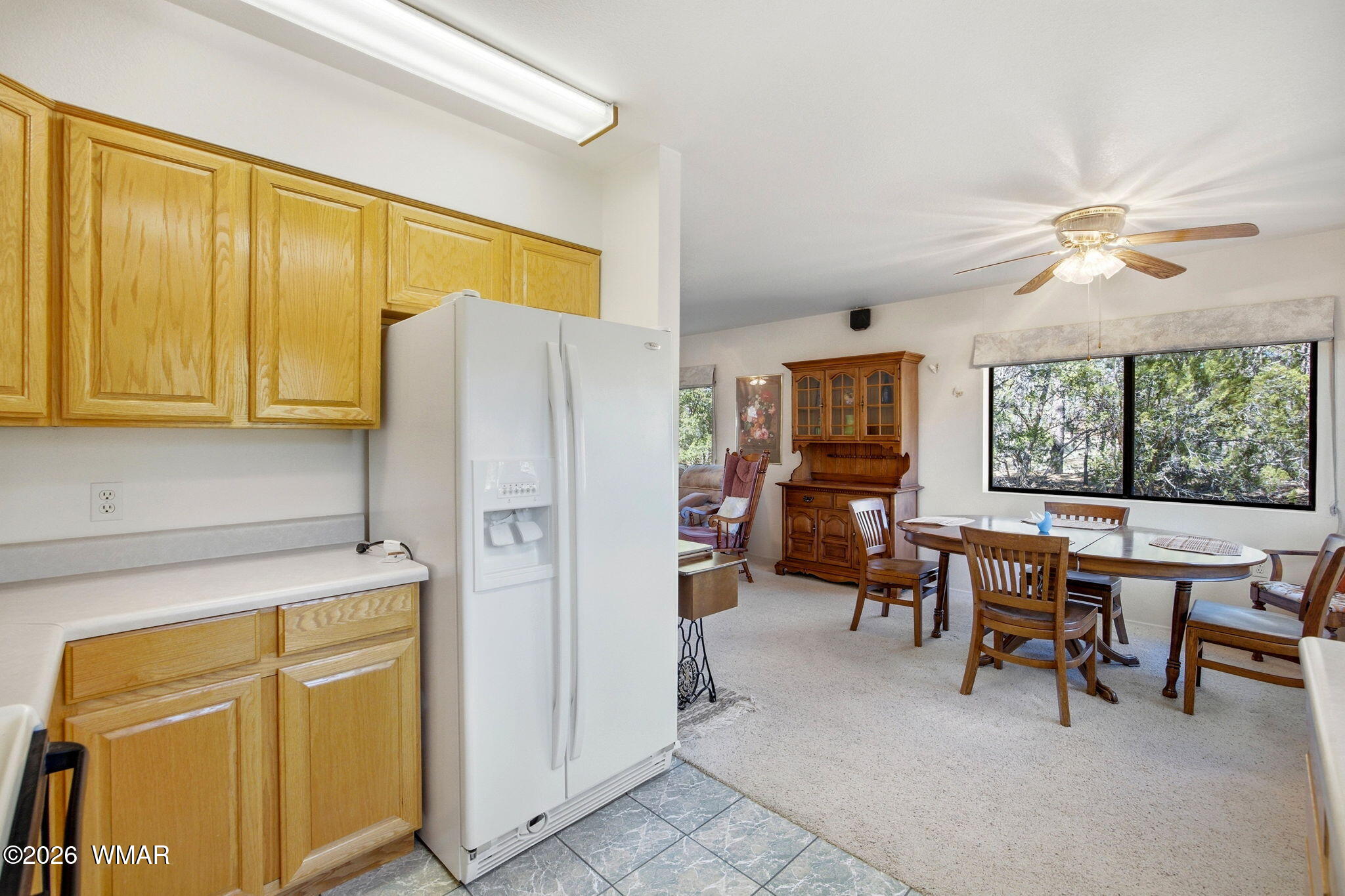 1924 Little Doe Trail Overgaard, AZ 85933 - Photo 12 of 31 a kitchen with a refrigerator a table and chairs in it