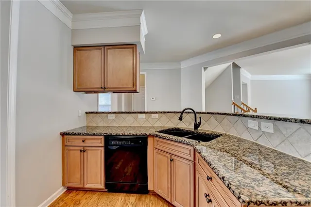 a kitchen with granite countertop a sink and a stove top oven