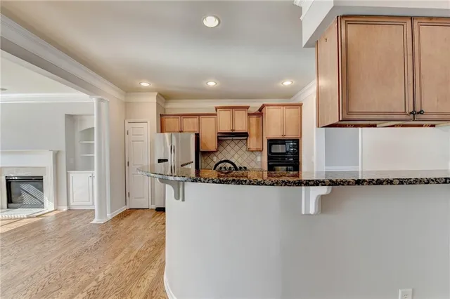 a view of a kitchen with kitchen island a sink stainless steel appliances and cabinets