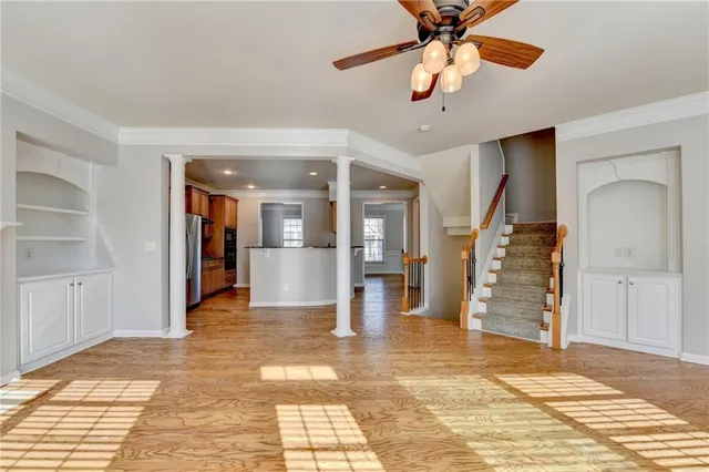 a view of a livingroom with wooden floor and a ceiling fan
