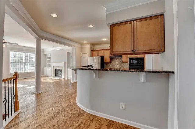 a view of a kitchen with wooden floor and a window