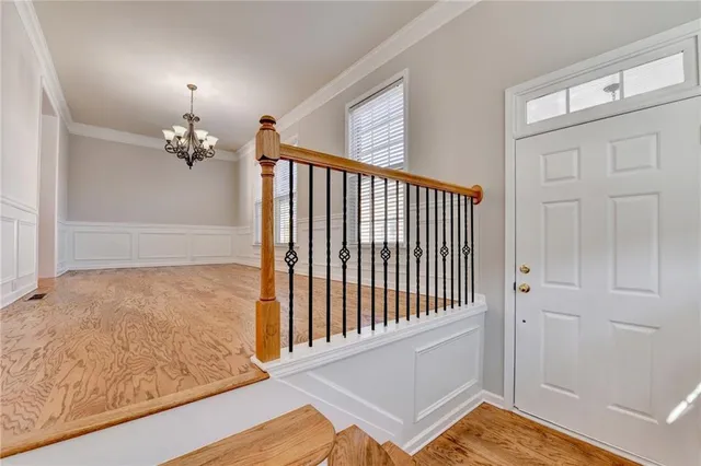 a view of a hallway with wooden floor and staircase