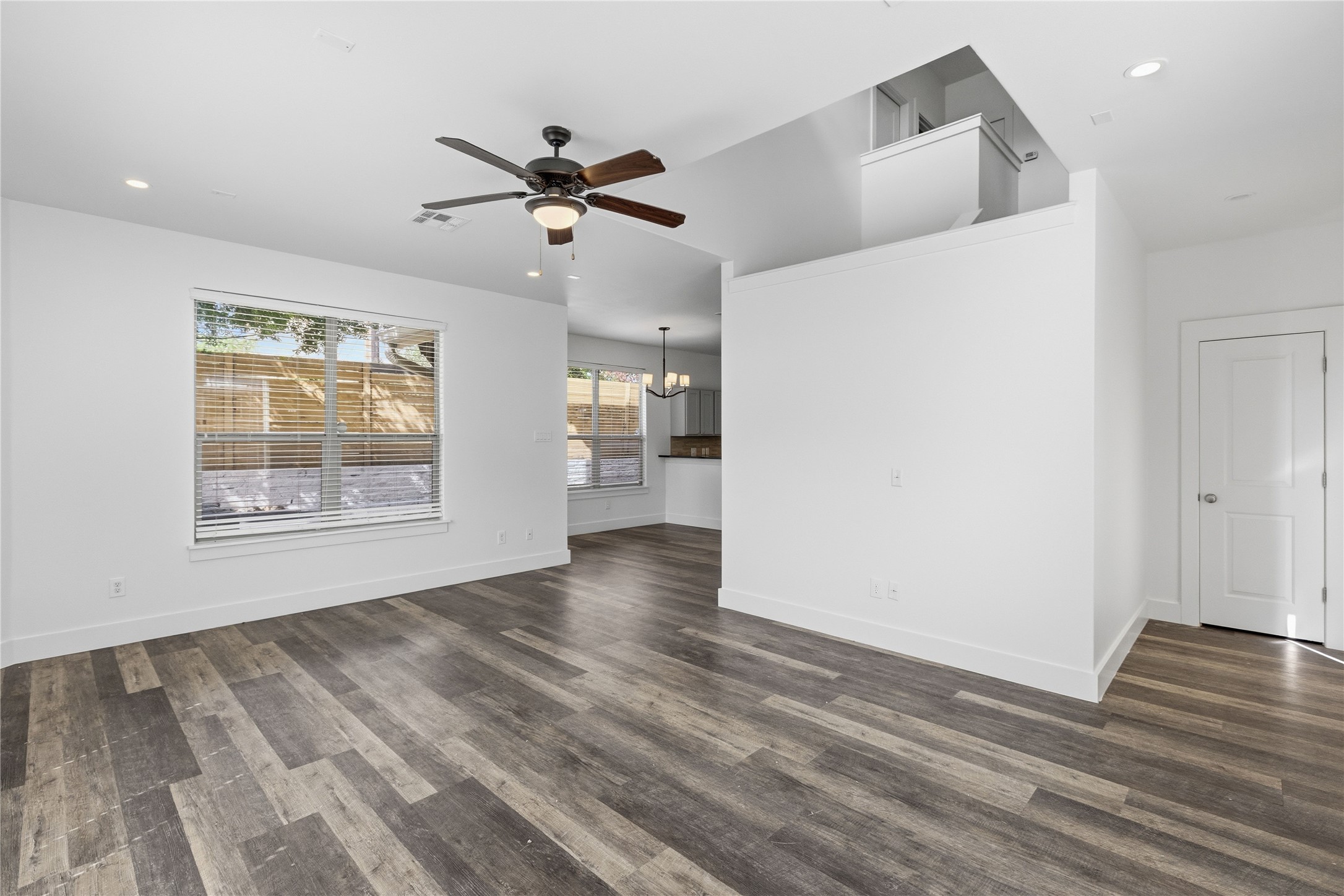 4124 Valley View Road, Unit 4A Austin, TX 78704 - Photo 11 of 37 A well-lit living area features robust wood-look flooring and a contemporary ceiling fan, ideal for comfortable daily living.