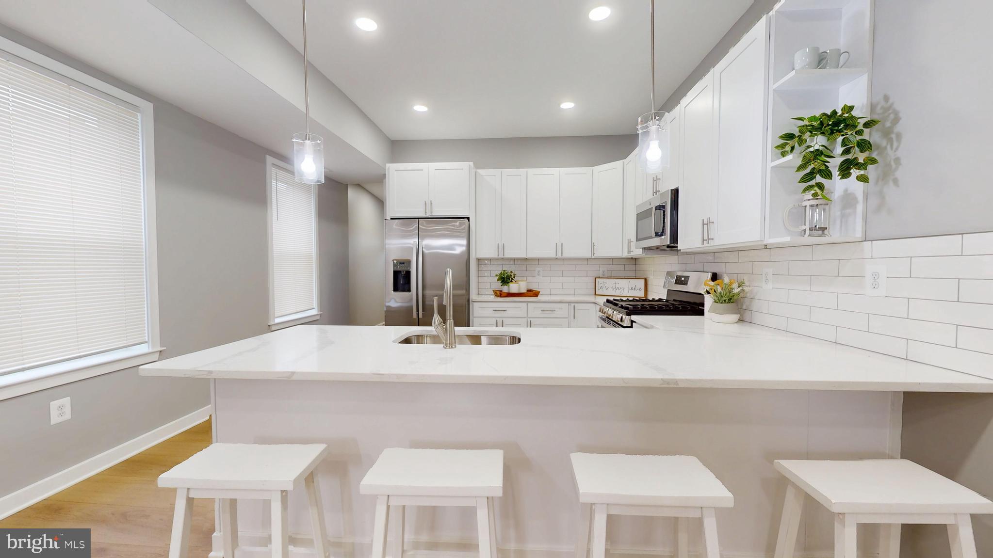 2519 East Fairmount Avenue Baltimore, MD 21224 - Photo 8 of 25 a kitchen with stainless steel appliances kitchen island granite countertop a sink a stove a refrigerator and cabinets