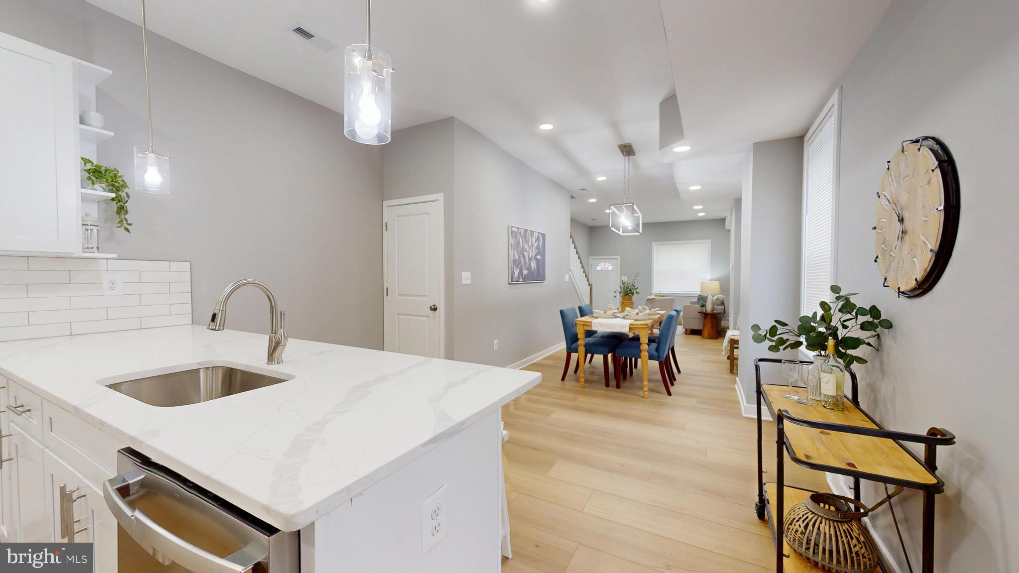 2519 East Fairmount Avenue Baltimore, MD 21224 - Photo 10 of 25 a large white kitchen with a white table chairs and a chandelier