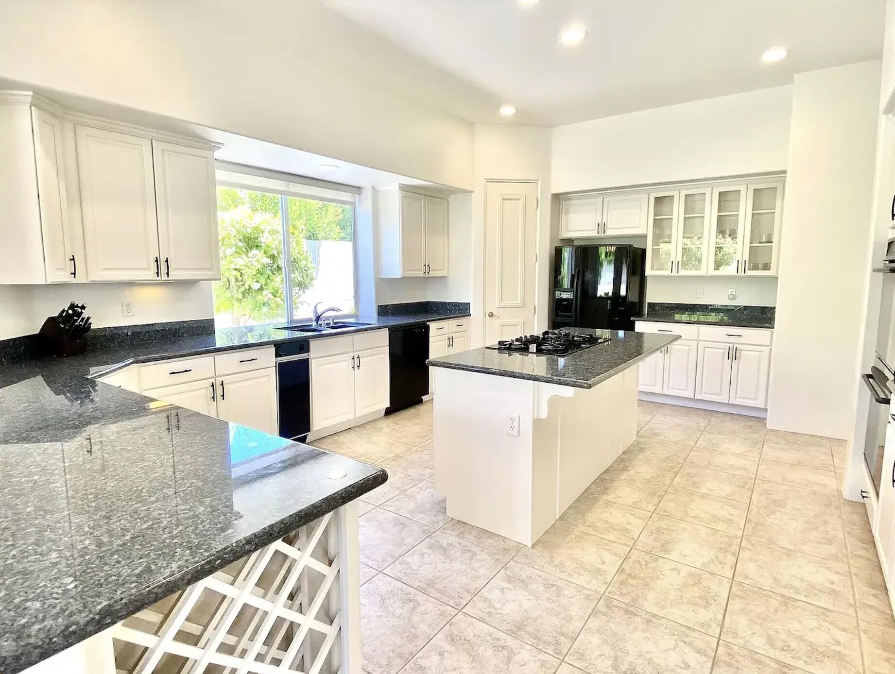 5 Victoria Falls Drive Rancho Mirage, CA 92270 - Photo 14 of 26 a kitchen with stainless steel appliances granite countertop a stove top oven a sink a counter top space and cabinets