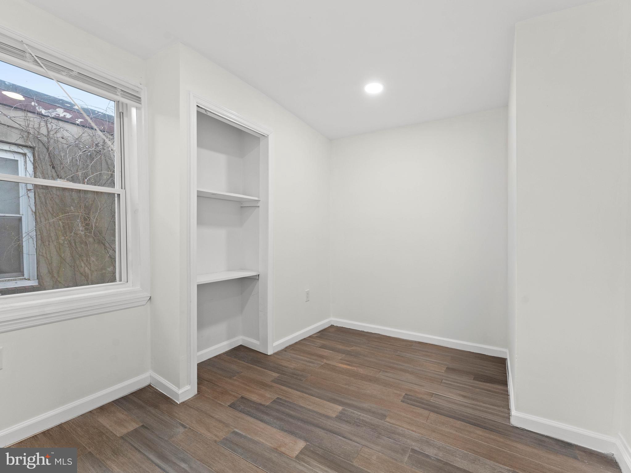 2443 Nicholas Street Philadelphia, PA 19121 - Photo 17 of 27 a view of an empty room with wooden floor and a window