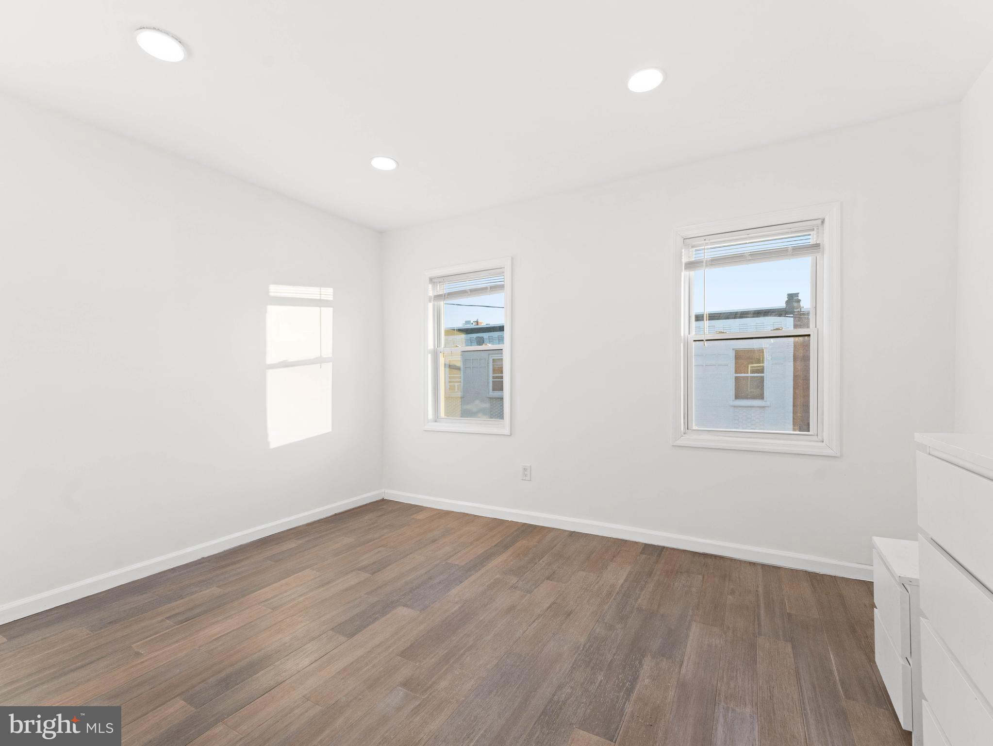 2443 Nicholas Street Philadelphia, PA 19121 - Photo 21 of 27 an empty room with wooden floor and windows