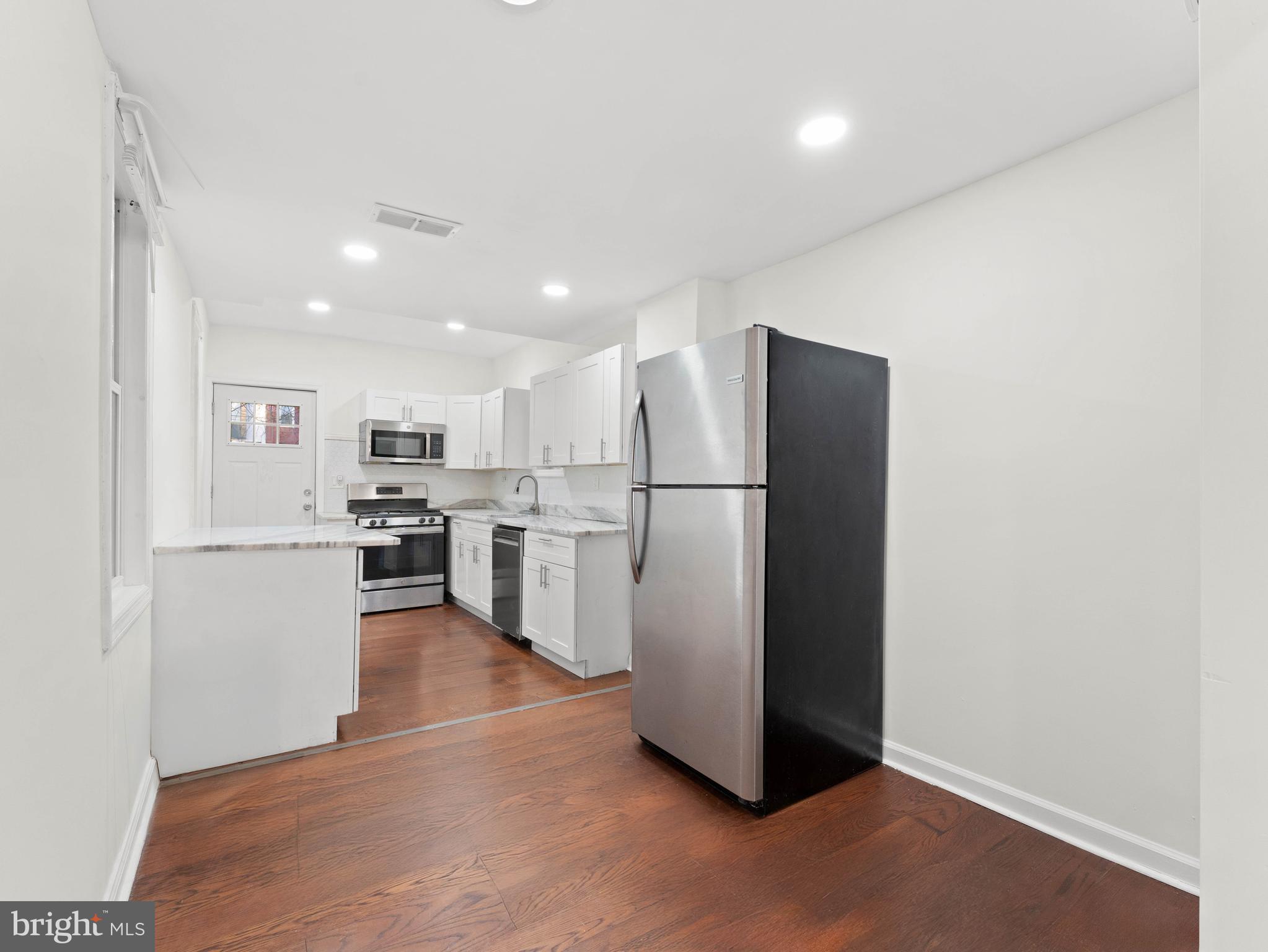 2443 Nicholas Street Philadelphia, PA 19121 - Photo 5 of 27 a kitchen with stainless steel appliances a refrigerator and a stove top oven