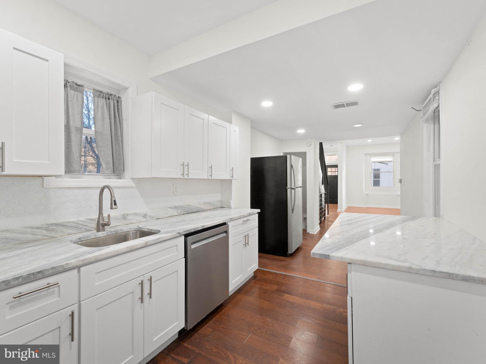 2443 Nicholas Street Philadelphia, PA 19121 - Photo 7 of 27 a large kitchen with stainless steel appliances granite countertop a refrigerator a sink and a stove
