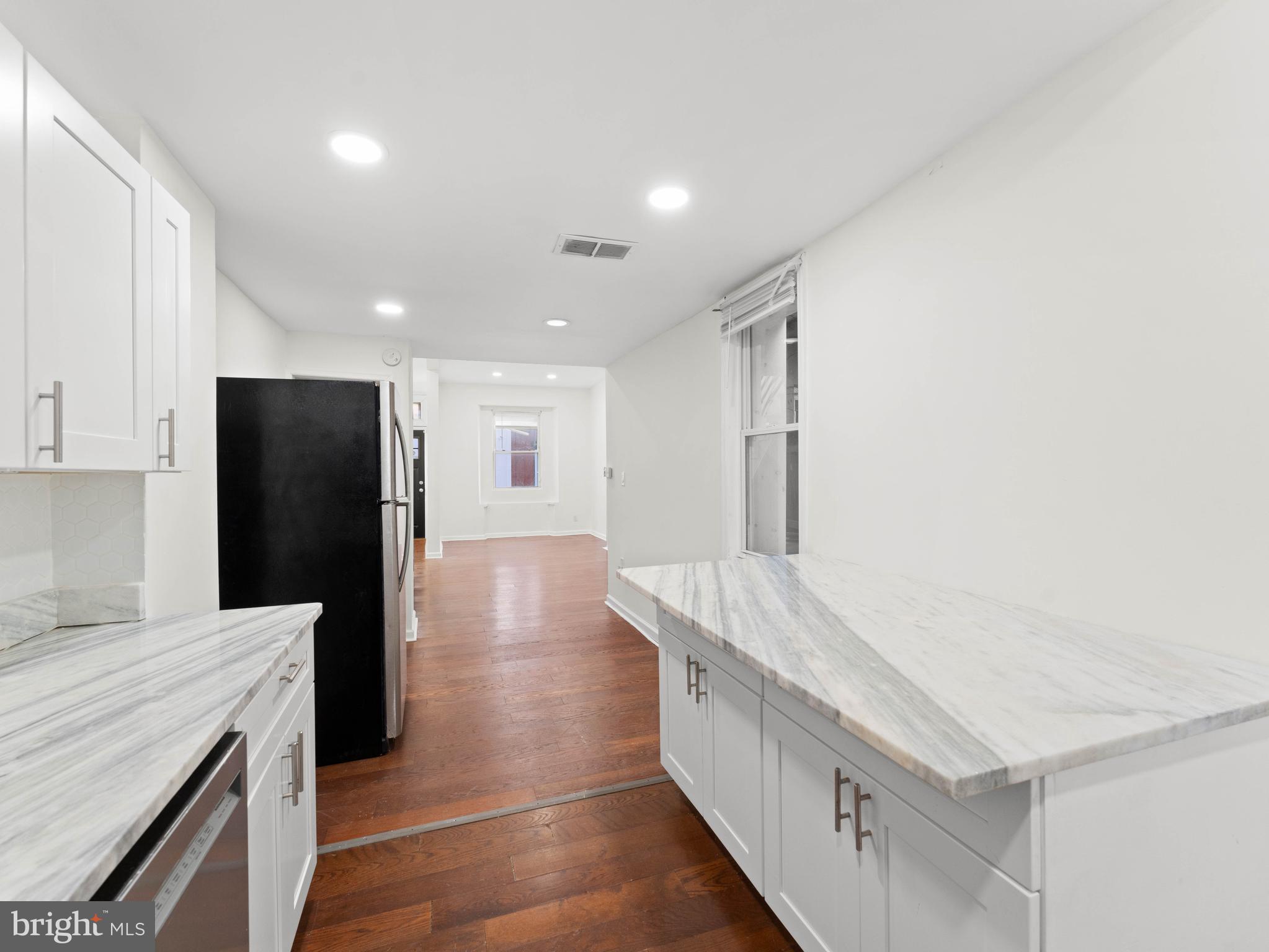 2443 Nicholas Street Philadelphia, PA 19121 - Photo 8 of 27 a kitchen with stainless steel appliances kitchen island granite countertop a refrigerator and a sink