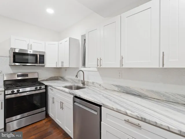 a kitchen with appliances a sink and cabinets