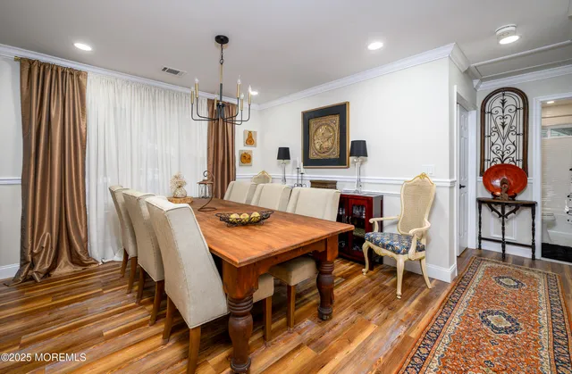 a view of a a dining room with furniture window and wooden floor