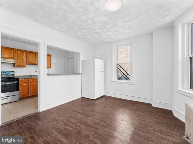a view of a kitchen with wooden floor and electronic appliances