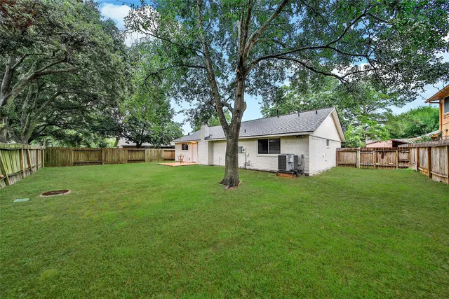 a view of a house with backyard and a tree