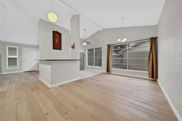 a view of empty room with wooden floor and window