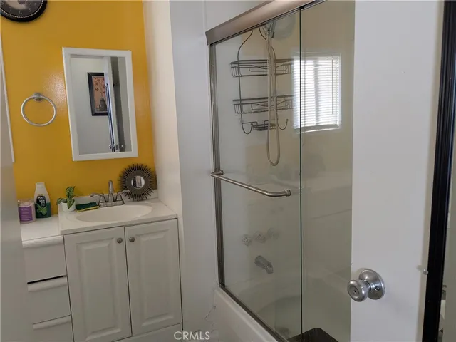 a bathroom with a sink a mirror and shower