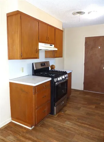a kitchen with stainless steel appliances granite countertop a stove a sink and a microwave