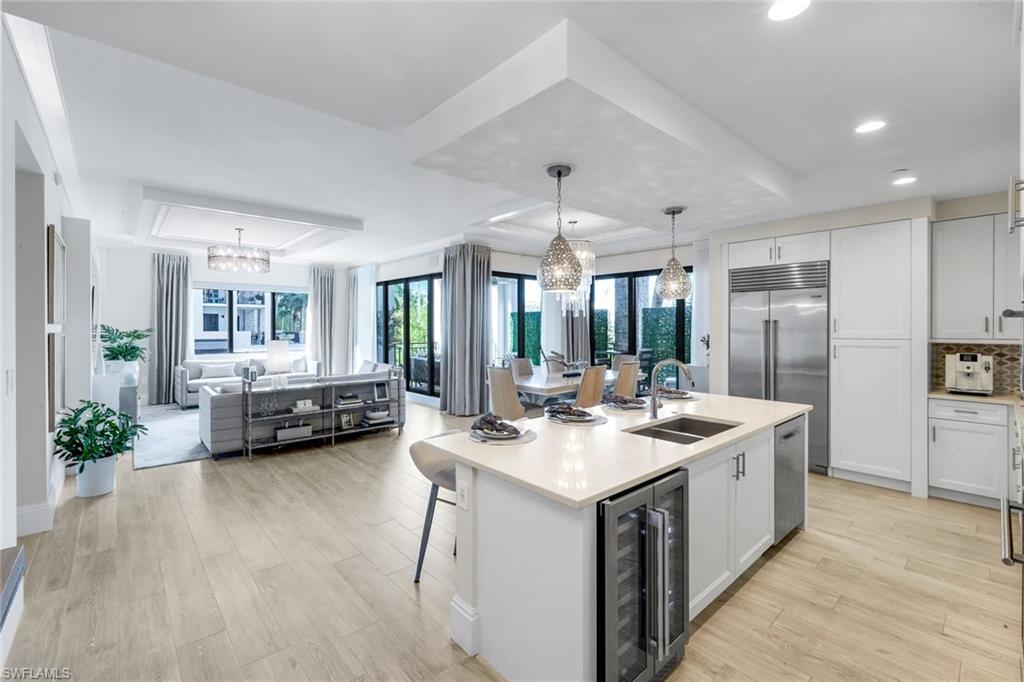 1135 3rd Avenue South, Unit 209 Naples, FL 34102 - Photo 7 of 31 Chef's Kitchen with Quartz Island - Wine Refrigeration - Great Room - Dining out to wrap around covered lanai