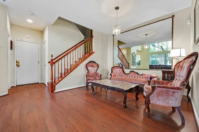 a living room with furniture a window and wooden floor