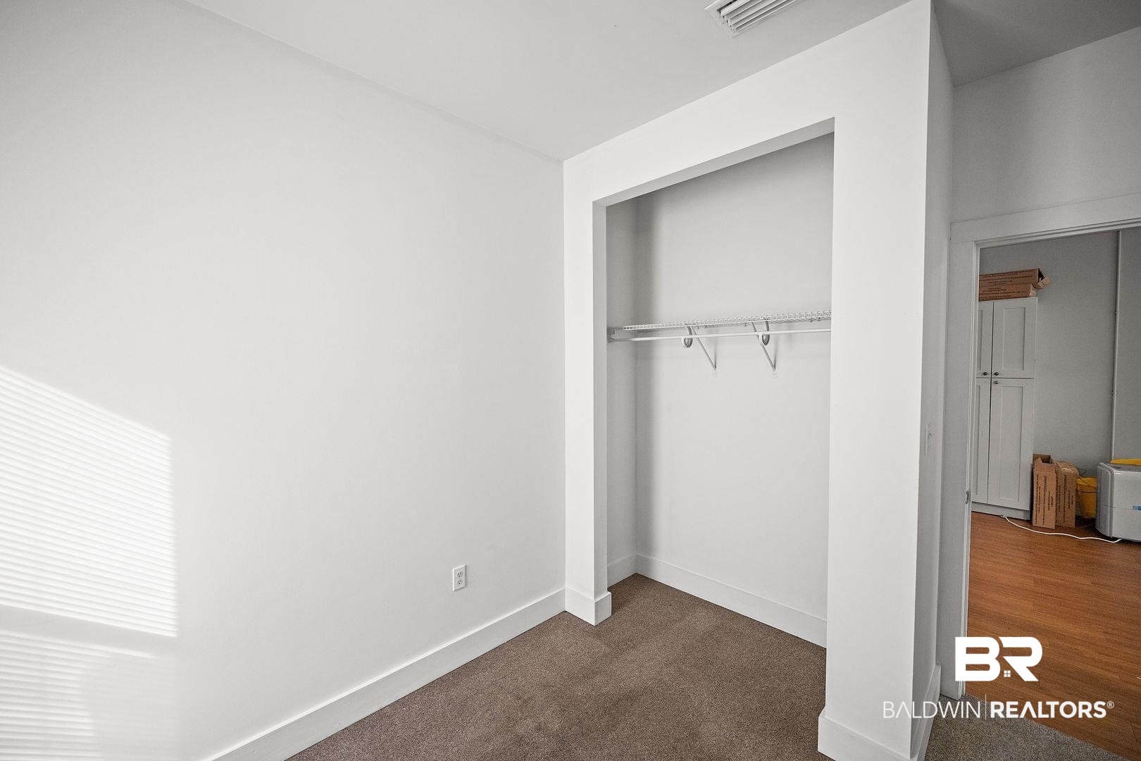 635 East Azalea Avenue Foley, AL 36535 - Photo 7 of 18 Carpeted room featuring a built-in closet with wire shelving, white walls, and a window with horizontal blinds