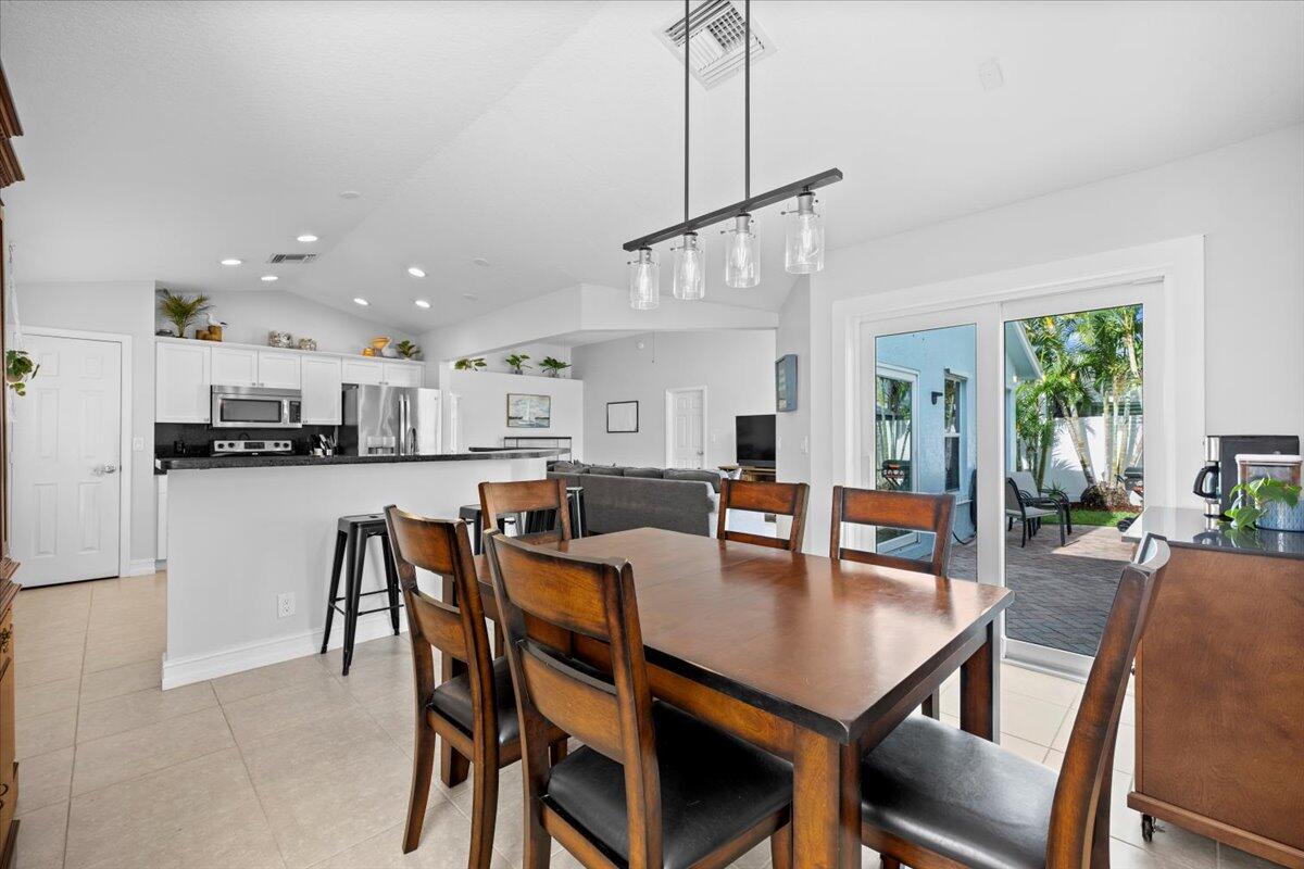 6377 Barbara Street Jupiter, FL 33458 - Photo 1 of 23 a view of a dining room and livingroom with furniture wooden floor a chandelier