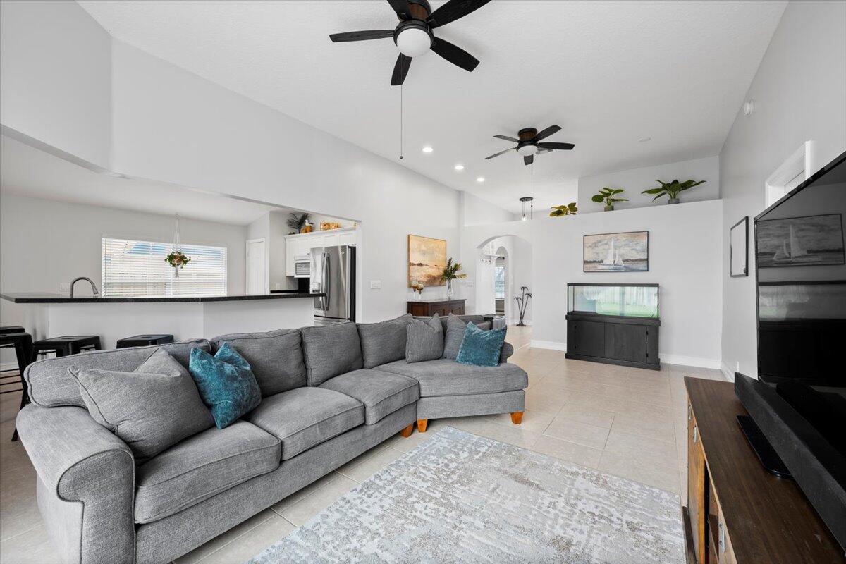 6377 Barbara Street Jupiter, FL 33458 - Photo 14 of 23 a living room with furniture kitchen view and a fireplace