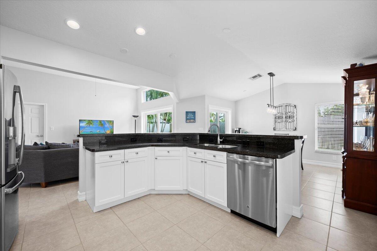 6377 Barbara Street Jupiter, FL 33458 - Photo 7 of 23 a kitchen with stainless steel appliances a sink and cabinets