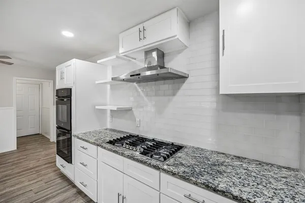a view of a livingroom with wooden floor and a flat screen tv