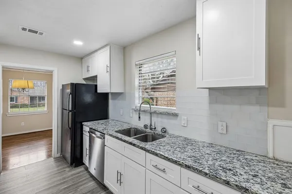a kitchen with stainless steel appliances granite countertop a refrigerator and a sink