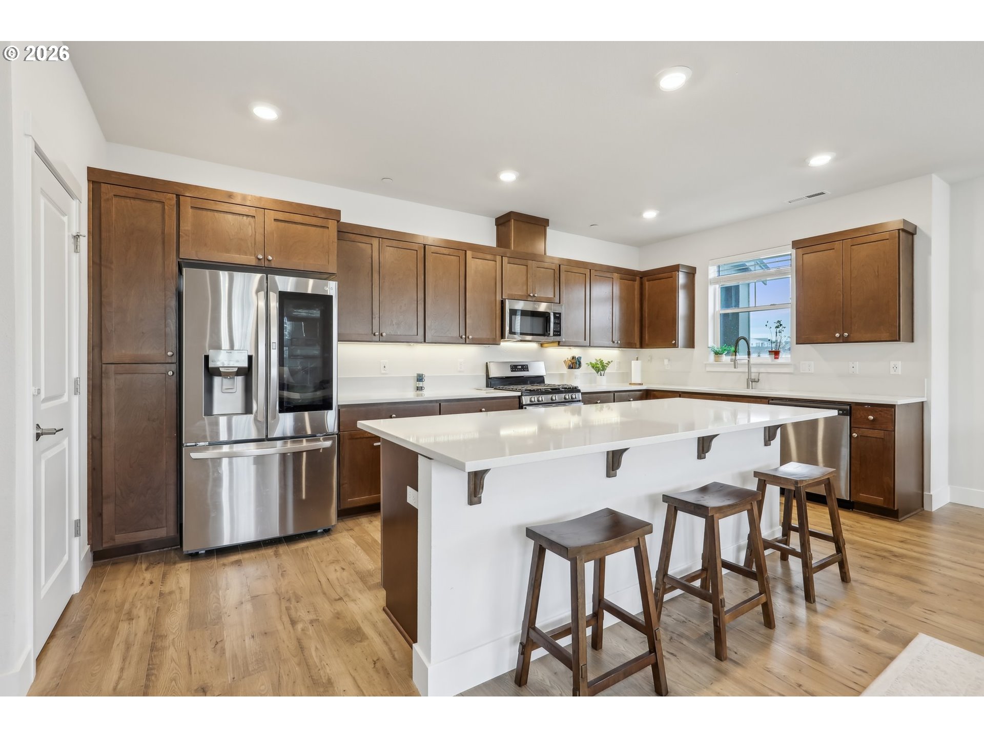 18436 Southwest Buckhorn Drive Beaverton, OR 97007 - Photo 11 of 35 a kitchen with stainless steel appliances granite countertop a refrigerator a stove a sink a dining table and chairs